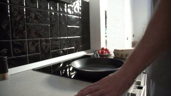厨房一名男子在煎锅上倒油做早餐