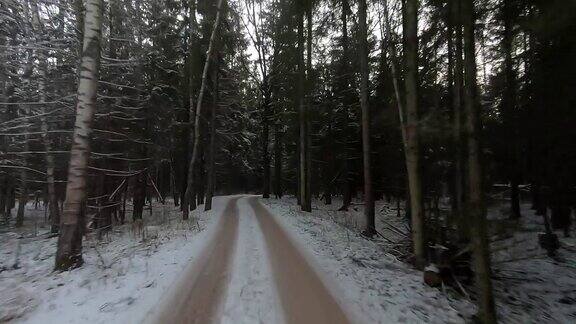 视频驾驶一辆车在积雪的森林道路在冬天日落在野外开车旅行