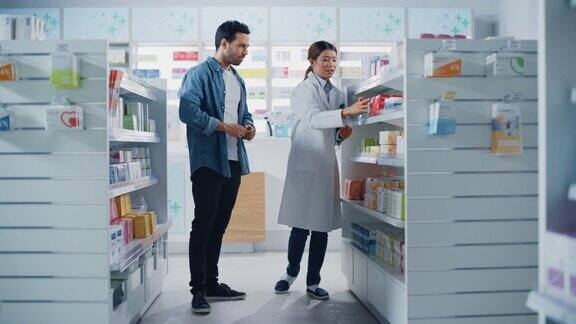 药店:女性亚洲药剂师帮助拉丁男性客户与推荐并建议购买药物药物维生素现代药店货架与保健产品