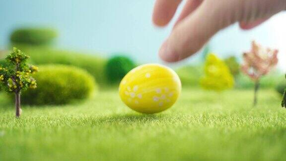手在草地上放复活节蛋