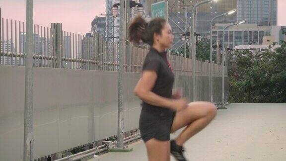 运动亚洲女子训练hi膝盖和热身跑步前