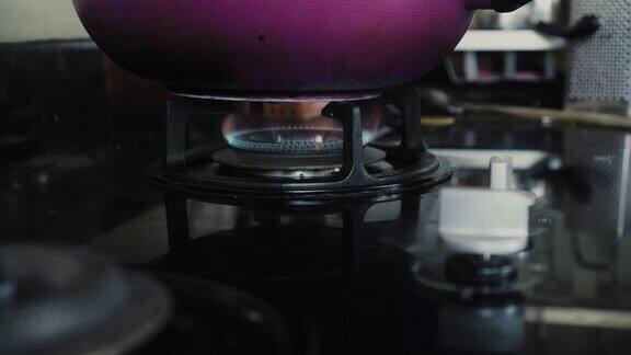 视频显示厨房里有一个黑色的煤气炉蓝色和红色的火焰在燃烧