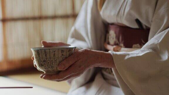 日本茶道主持人手中一碗热气腾腾的茶