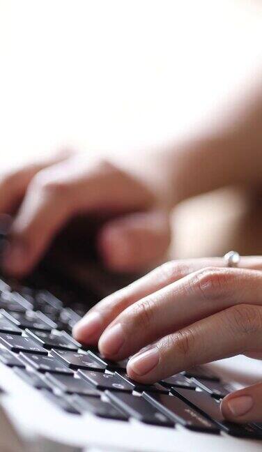年轻女性在家使用笔记本电脑工作关闭手打字笔记本键盘