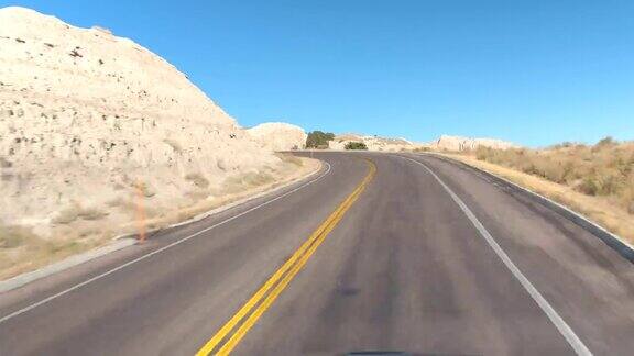 延时拍摄:驾车沿着空旷的道路穿过风景优美的Badlands山沙漠