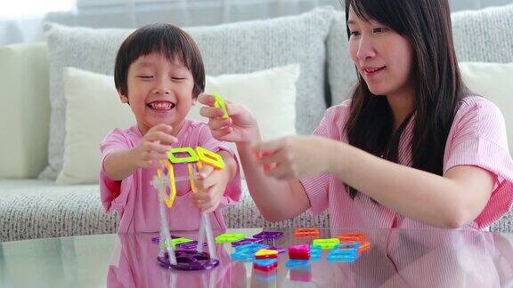 母亲和儿子在家里玩磁铁