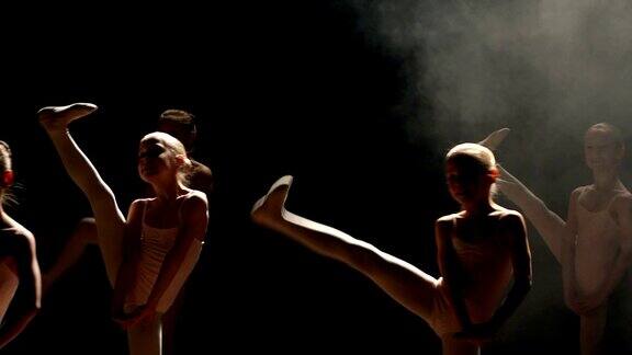 一群芭蕾舞者在黑暗中在舞台上跳舞