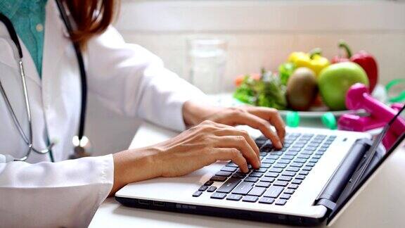 营养师通过笔记本电脑为患者提供健康的水果和蔬菜正确的营养和饮食概念的咨询