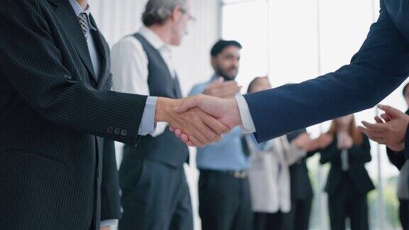 商务人士在成功会面后握手达成交易协议商业伙伴握手商界人士在背后拍手伙伴关系