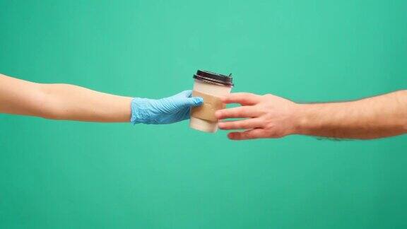 人们的手互相传递着咖啡去咖啡递送以薄荷为背景