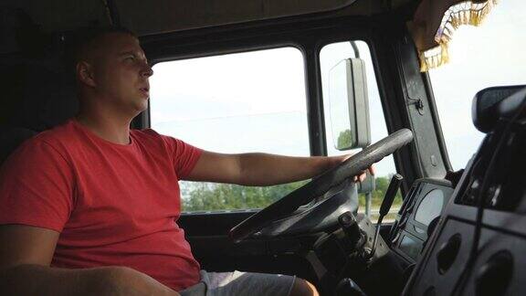 卡车司机手握方向盘控制卡车驶向目的地在夏日驾驶汽车穿越乡村的男子在乡村公路上行驶的卡车司机物流近距离