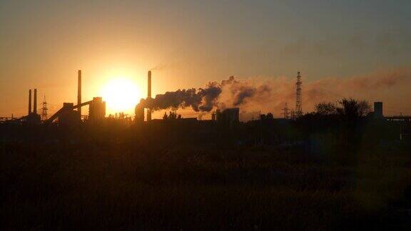 黎明时分太阳从工厂的烟囱里冒出来