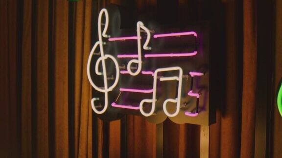 复古风格的霓虹灯音符牌挂在俱乐部或酒吧的墙上五颜六色的霓虹灯闪烁在老式的招牌或横幅缓慢的运动近距离拍摄相机移动