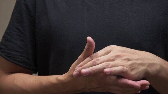 穿着黑色衬衫的亚洲人感到手指疼痛肌肉疼痛保健理念