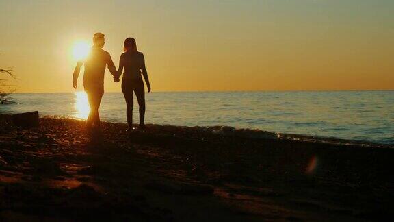 日落时分在海边散步的情侣