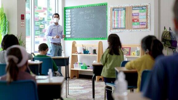 2019冠状病毒病期间戴口罩的学生在教室里