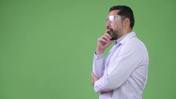 侧面的英俊的波斯胡子男子医生戴着防护眼镜和思考