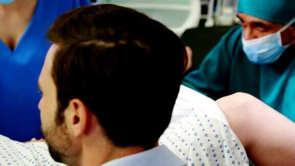 医生检查孕妇分娩时男子在手术室握着她的手