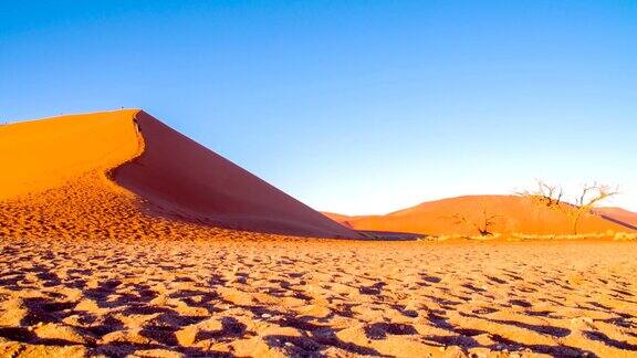 游客在纳米比亚沙漠的沙丘上