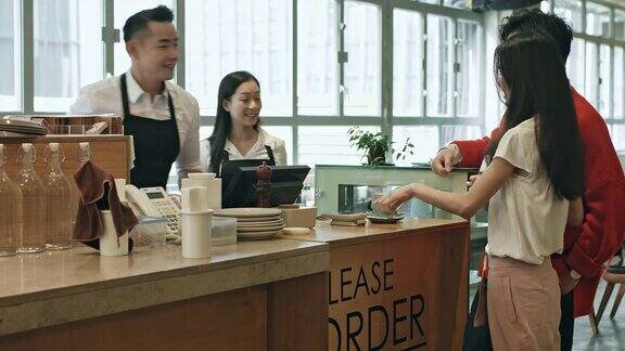 中国成熟的咖啡师在咖啡馆为顾客提供咖啡