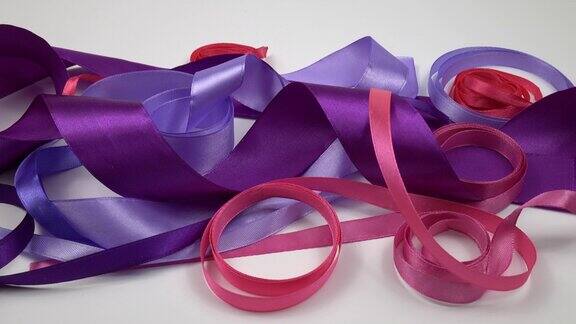 白色的背景上点缀着紫色和粉色的缎带
