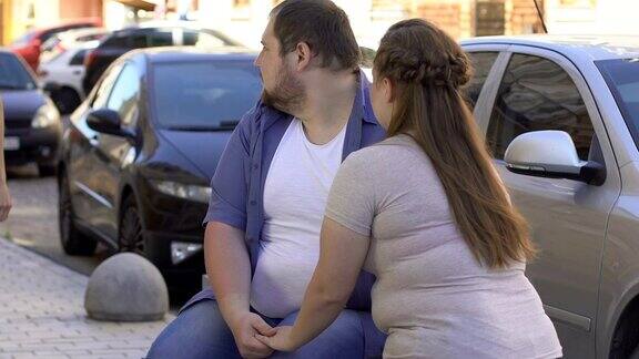 肥胖的男友看着苗条的女士超重的女友嫉妒而生气