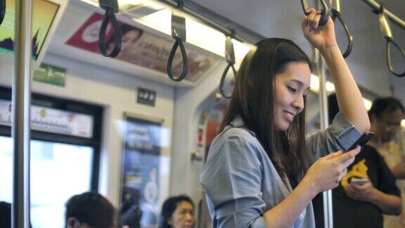 亚洲女性在火车上使用手机