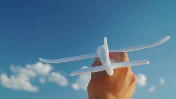 一个男人的手拿着一架玩具飞机飞向天空创意和梦想的商业理念