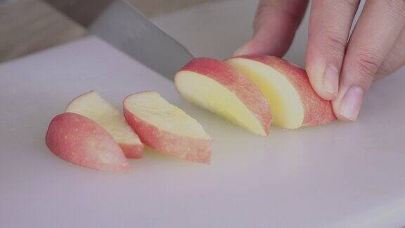 女人把水果和苹果切成薄片作为健康的早餐放在桌上