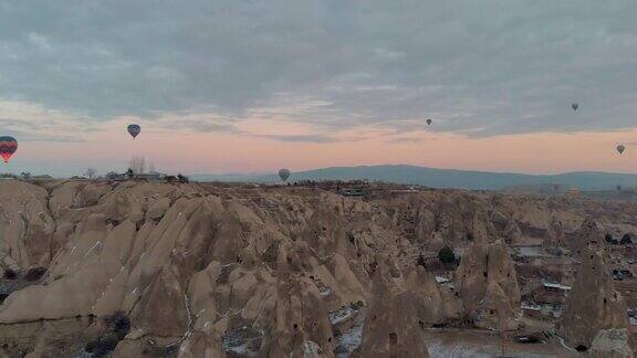在卡帕多西亚日出时彩色的热气球飞过白雪仙女的烟囱