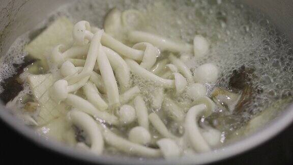 SLOMO:特写的白色Shimeji蘑菇煮在滚烫的汤