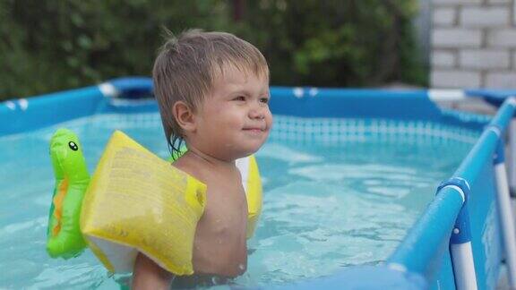 穿着长袖衣服的孩子在院子里的游泳池里游泳戏水