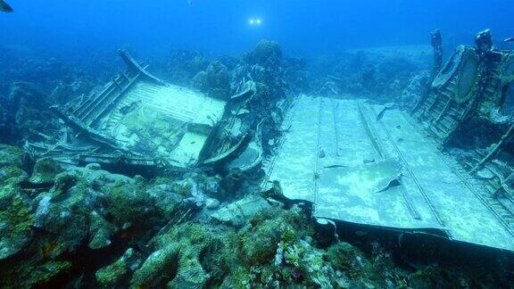 飞机残骸作为珊瑚礁的一部分在加勒比海库拉索岛周围的蓝色背景