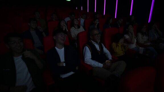 广角的亚洲华人群在电影院看喜剧电影笑