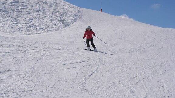 滑雪者滑下山坡在山上雕刻转弯飞溅雪