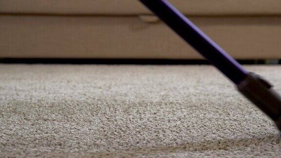 一位妇女用吸尘器清洁地毯近距离