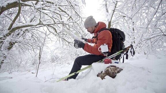 一个徒步旅行者在休息时间查看雪山地图