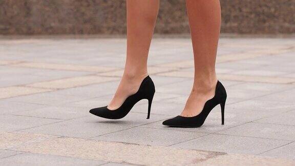 女人们穿着高跟鞋走在城市的街道上穿着高跟鞋的年轻女商人的脚在城市中穿行女孩走着去上班近距离