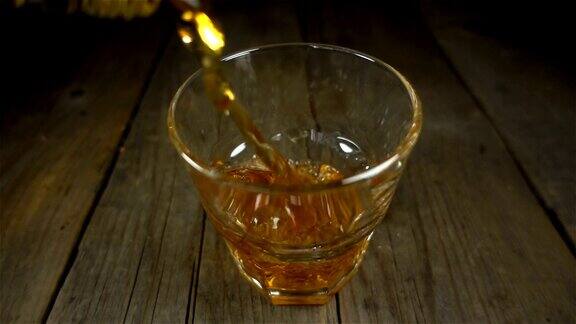 威士忌以慢动作从瓶子里倒进玻璃杯