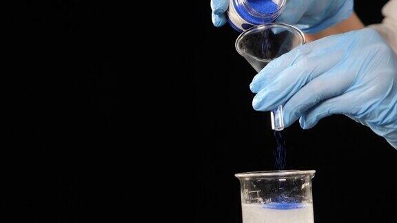 在化妆品或香水生产的化学实验室中实验室工作人员倒蓝色的化学物质香水提取物美容缓慢的运动全高清