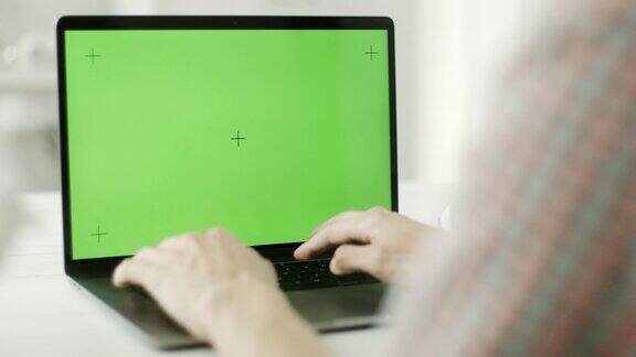一个人在用绿色屏幕的笔记本电脑