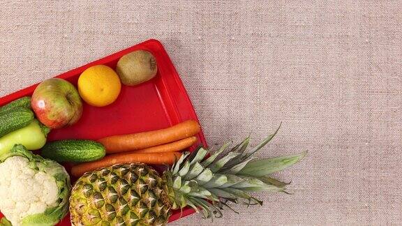 新鲜的水果和蔬菜出现在主题左侧的红色托盘停止运动