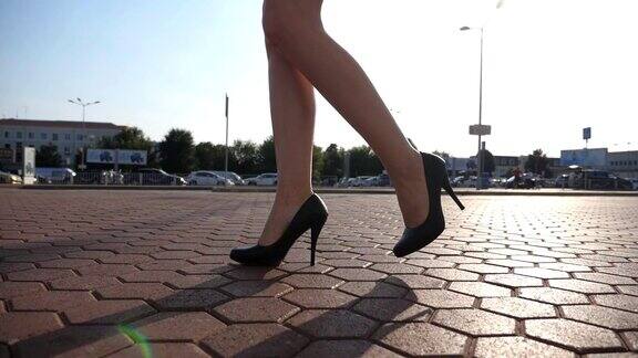 女人们穿着高跟鞋走在城市的街道上穿着高跟鞋的年轻女商人的脚在城市中穿行一个女孩在阳光明媚的日子里走着去上班慢动作特写侧视图
