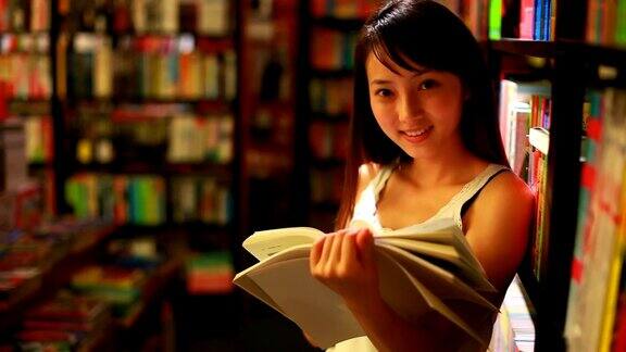 年轻漂亮的女人在图书馆看书