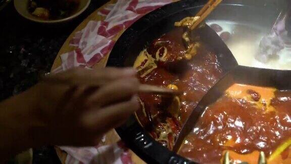 在中国的麻辣火锅汤里煮一片生猪肉