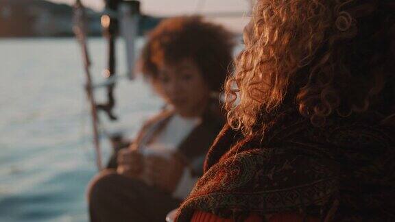 黄昏时分两个女人在帆船的甲板上喝咖啡