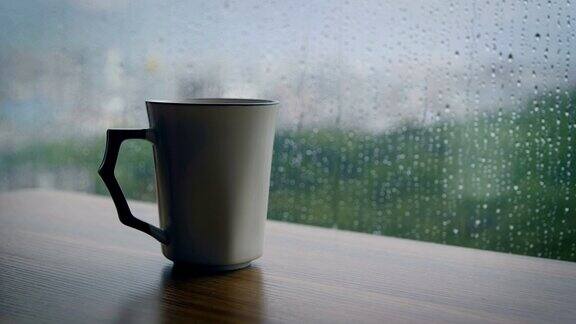 咖啡杯放在桌上雨滴落在窗户上
