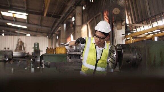 戴安全帽穿着安全夹克的工业工程师在重工业制造工厂工作