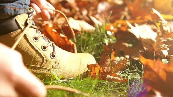 孩子系好鞋带在秋天的公园散步