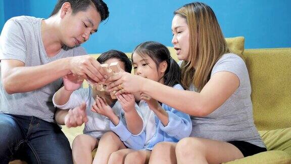 亚洲家庭在家里玩拼图游戏